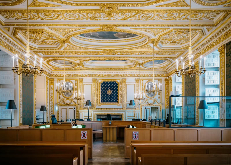 Ornate gilded assembly hall interior with rows of benches